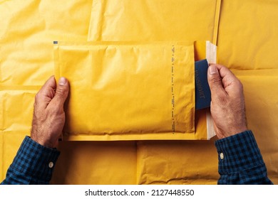 Male Hands Packing Yellow Bubble Envelopes For Shipping.