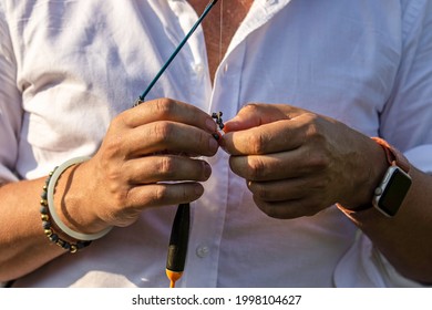 Male Hands Put Bait On A Fishing Rod's Hook. Fishing With A Spinning Rod