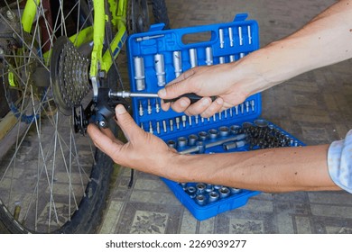 male hands repairing a bicycle,rear derailleur adjustment on a bicycle, bicycle repair shop