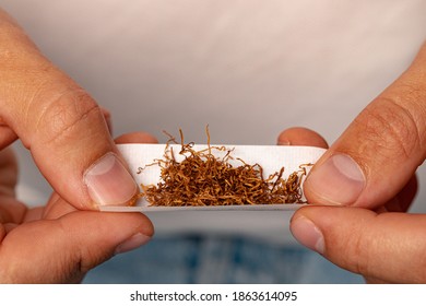 Male Hands Rolling Tobacco In Cigarette Paper