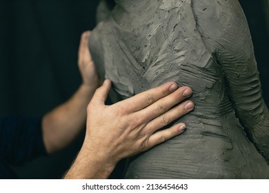 Male hands sculptor creates sculpt bust clay human woman sculpture. Statue craft creation workshop close up