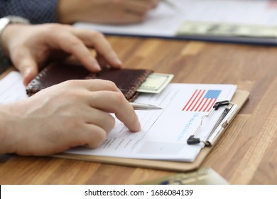 Male hands in suit lie on application for usa visa. Registration in the system embassies. Priority clearance. Checking petition and paying consular fee. Increase chances getting visa - Shutterstock ID 1686084139