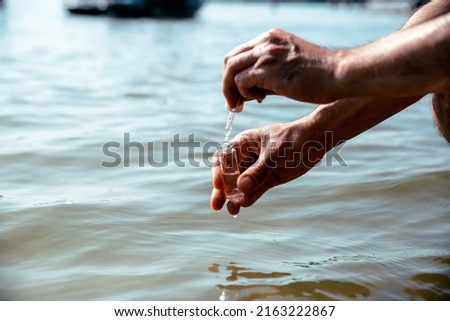 Male hands taking sample of the  water for analyzing and control environment pollution. Close up background. Copy space