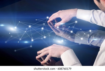 Male hands touching interactive table with blue connectivity graphic in the background - Shutterstock ID 608760179