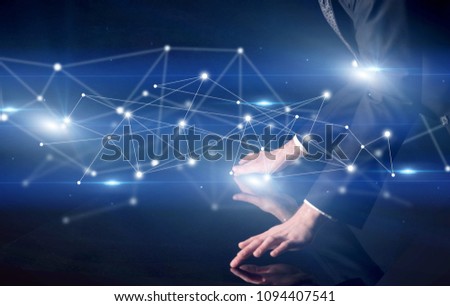Male hands touching interactive table with blue connectivity graphic in the background