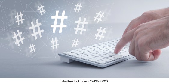 Male hands typing in computer keyboard. Hashtag. Social media