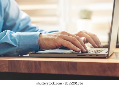 Male hands typing on a laptop keyboard - Shutterstock ID 2055201536