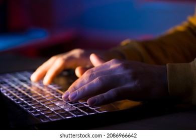 Male hands are typing on a laptop keyboard, a man works, develops a business, studies, plays a computer game at night. Close-up view. - Shutterstock ID 2086966642
