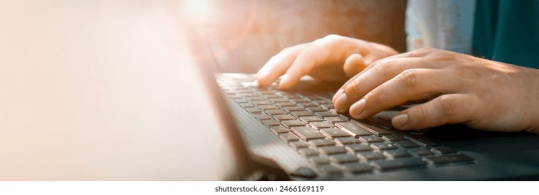 Male hands are typing on a laptop keyboard, a man works, develops a business, studies, plays a computer game. Close-up view in a daylight. - Powered by Shutterstock