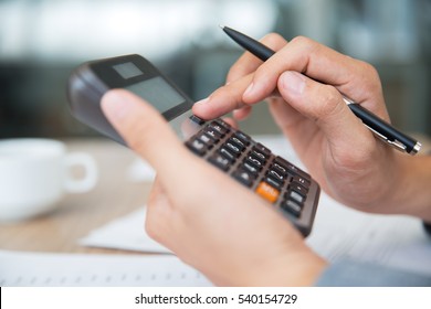 Male Hands Using Calculator