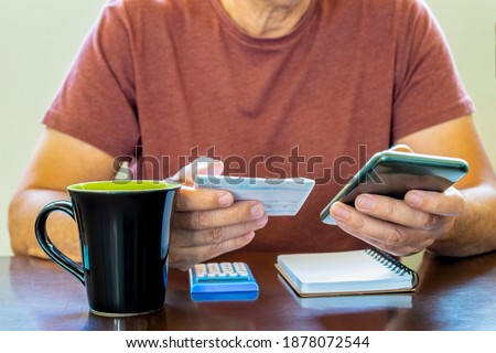 Male hands using calculator apps at desk. minimum wage increase. open banking. income tax return in brazil. restitution. aid brazil. irpf 2022

