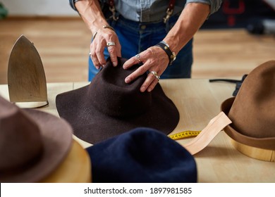 male hats maker shape the hat in workshop, holding perfectly made hat for customers. successful adult business man employed at his own business - Powered by Shutterstock