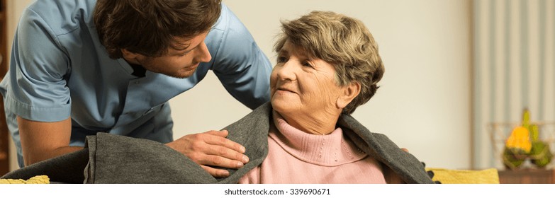 Male Helpful Caregiver Taking Care Of Senior Woman