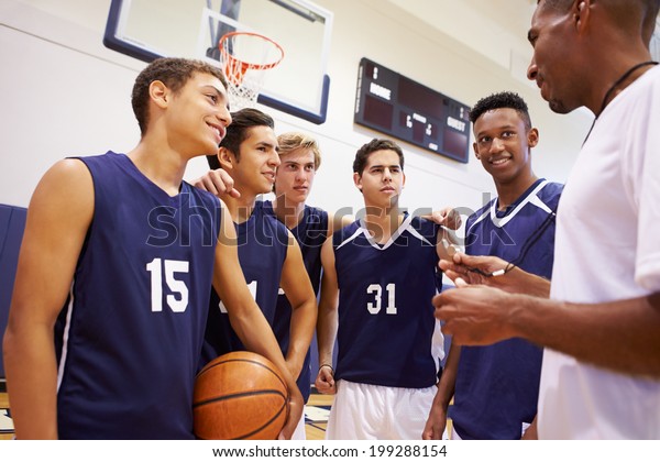 Male High School Basketball Team Having Team Talk\
With Coach