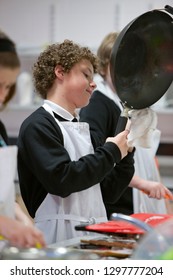 Male High School Student Cooking In Home Economics Class