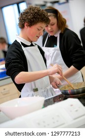 Male High School Student Cooking In Home Economics Class