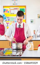 Male High School Student Cooking In Home Economics Class