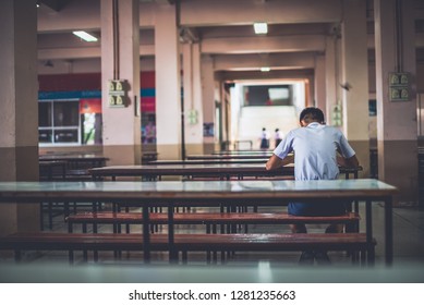 Male High School Student Is Sitting Alone In The School Cafeteria, Thailand, Southeast Asia.