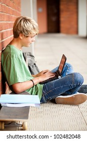 Male High School Student Using Laptop In School