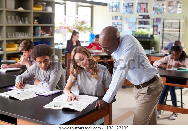 Male\
High School Tutor Teaching Students In Biology\
Class