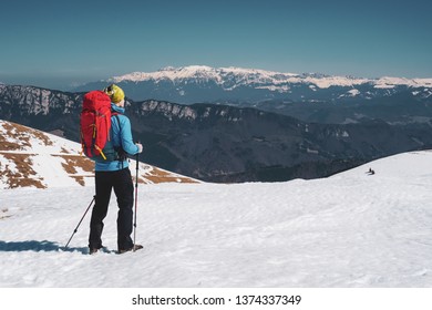 Male Hiker Hiking With Backpack Admiring The View Of Bucegi Mountains In Winter / Early Spring In Romania, Iezer-Papusa Mountains