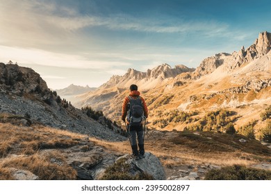 Male hiker hiking with enjoying the French Alps scenic and massif Des Cerces on autumn wilderness in Claree Valley at Hautes Alpes, France - Powered by Shutterstock