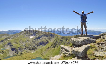 Male hiker in Rila mountains, Bulgaria, with arms stretched out to enjoy the mountain scenery