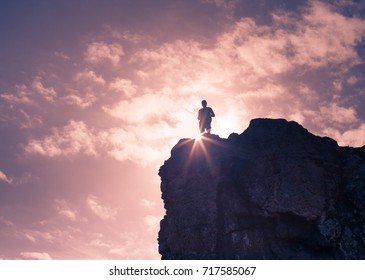 Male hiker standing on top of mountain edge looking out at the view.  - Shutterstock ID 717585067