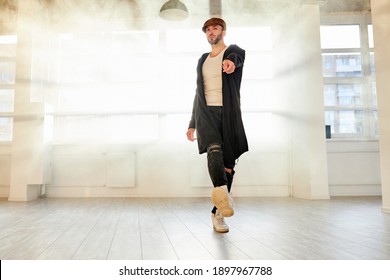 male hip-hop dancer in black casual wear performing dance in studio alone, rehearsal. active full of energy man preparing for concert