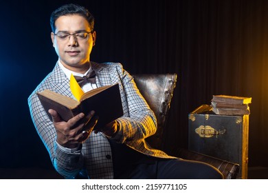 Male Historian. Man Is Studying History Books. Man Reads Old Books. Dark-haired Guy With Textbook. Guy In Plaid Jacket. Man With Book On Dark Background. Historian Studying Non-fiction