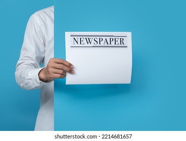 Male Holding Blank Business Newspaper On Blue Background,copy Space For Text