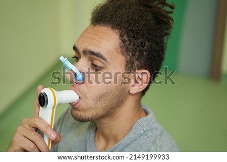 Male holding spirometer mouthpiece in his mouth