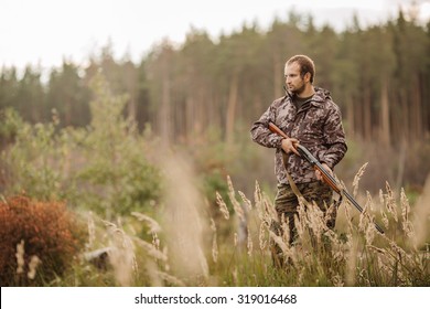 Male Hunter In Camouflage Clothes Ready To Hunt  With Hunting Rifle