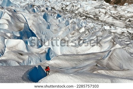 Male ice hiker in red jacket shot from behind on Mendenhall Glacier, Juneau, Alaksa