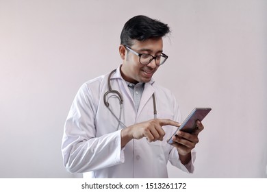 Male Indian Doctor In White Coat And Stethoscope Touching Smart Phone