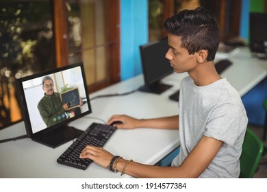 Male Indian Student Having A Video Call With Male Teacher On Computer At School. Distance Learning Online Education Concept