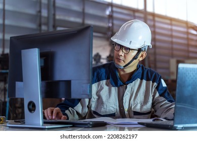 A Male Industrial Engineer Use Technology Works On The Personal Computer. Facility Operator Controls Workshop Production Line. Industry 4.0 Modern Factory Concept.