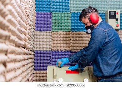 Male Industrial Worker With Protective Mask And Hearing Protectors Closing The Lid Of A Material Testing Machine