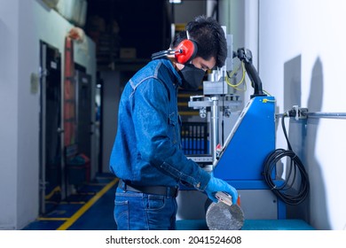 Male Industrial Worker With Protective Mask And Hearing Protectors Measuring A Concrete Cylinder On Test Laboratory