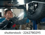 Male inspecting car wheel in the workshop