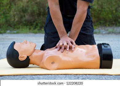 Male instructor showing CPR on training doll - Powered by Shutterstock