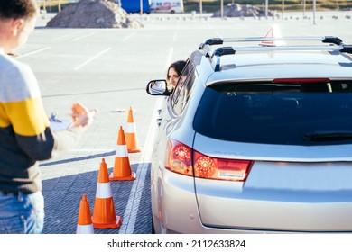 Male Instructor Teaching Learner Driver To Park A Car. Instructor And Student In Car During Exam On Test Track. Driving School