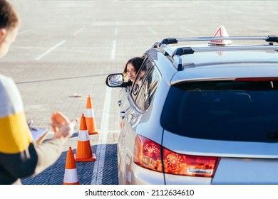 Male Instructor Teaching Learner Driver To Park A Car. Instructor And Student In Car During Exam On Test Track. Driving School
