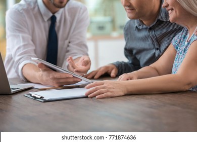 Male Insurance Agent Consulting Clients In Office