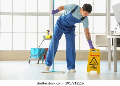 Male Janitor Mopping Floor In Office