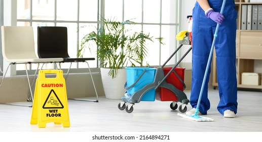 Male Janitor Mopping Floor In Office