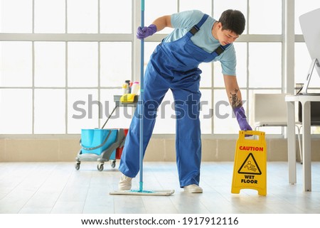 Male janitor mopping floor in office Foto d'archivio © 