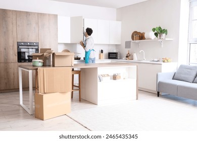 Male janitor opening cupboard in kitchen on moving day, back view - Powered by Shutterstock