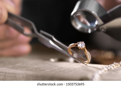 Male jeweler examining diamond ring in workshop, closeup view