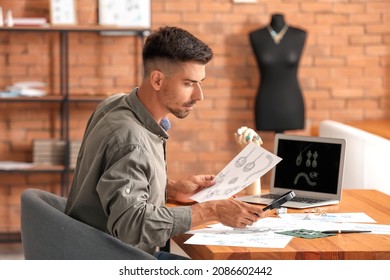 Male jewelry designer with sketches working in office - Powered by Shutterstock